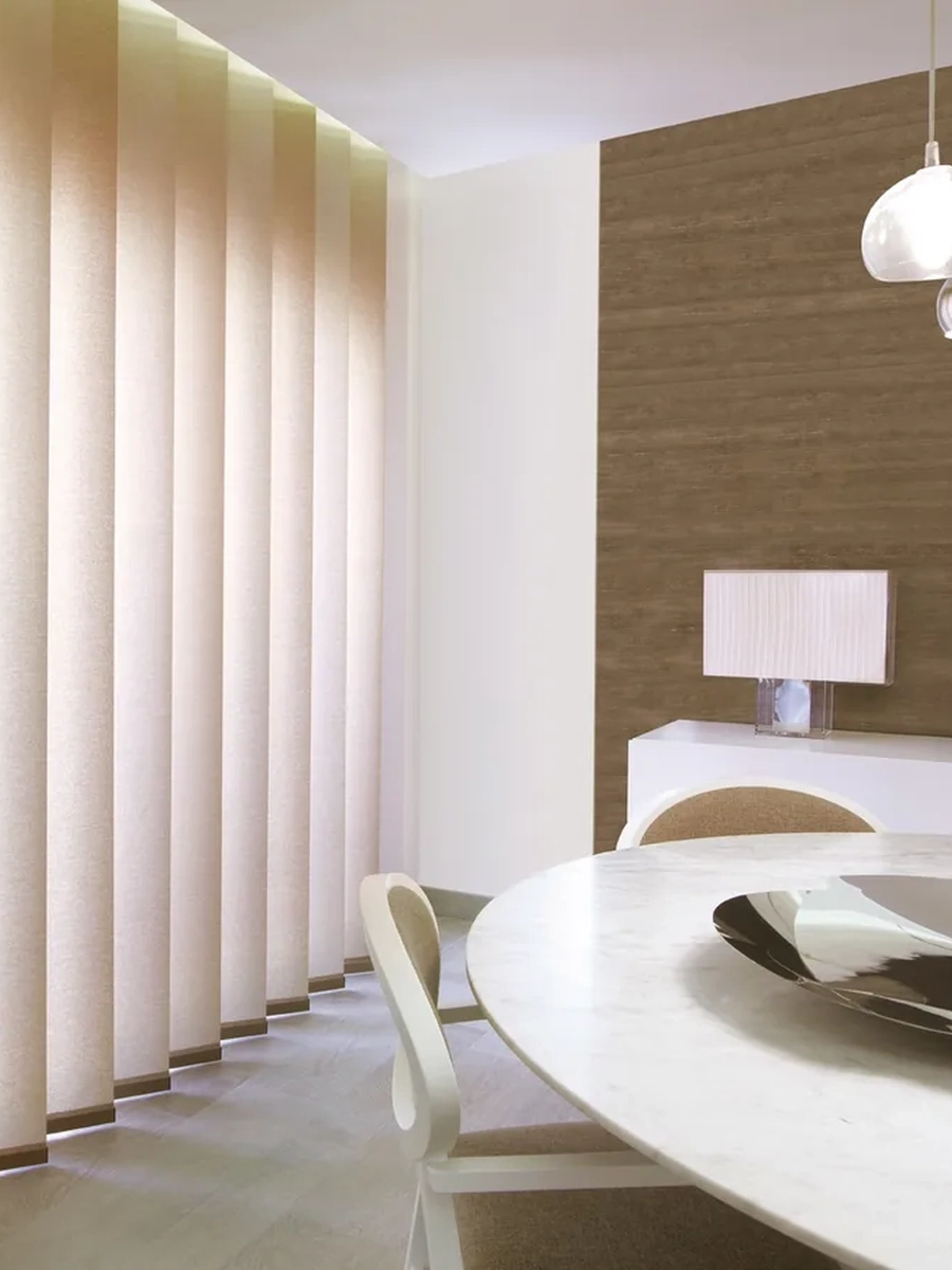Cortinas tipo paneles japoneses que filtran la luz natural y aportan calidez al salón.
